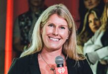 Lainie Fertick holding an iHeartMedia microphone while presenting