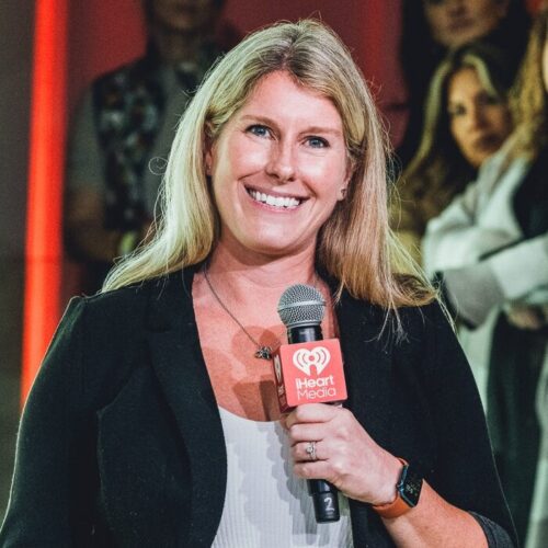 Lainie Fertick holding an iHeartMedia microphone while presenting