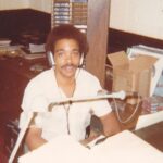Blast From The Past: Ronnie Love Ronnie Love seated at a microphone in the WJBE studio, wearing headphones